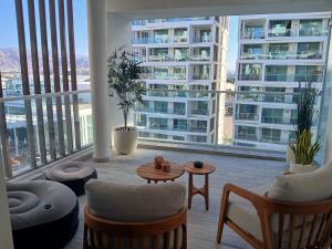 a balcony with chairs and tables and a large building at Amor Club Luxury Suite in Eilat