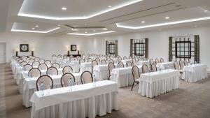ein Raum voller Tische und Stühle mit weißen Tischdecken in der Unterkunft Pine Cliffs Suites in Albufeira + 86 Fotos