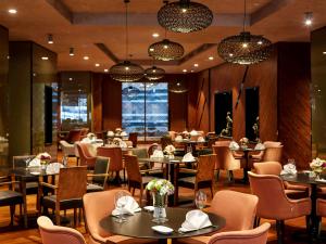 a restaurant with tables and chairs and chandeliers at Prime Istanbul Residences in Istanbul