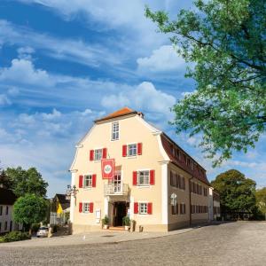 a large white building with red shutters on a street at Doppelzimmer 18 in Heidenheim