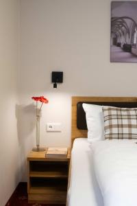 a bedroom with a bed and a table with a flower at Einzelzimmer 13 in Heidenheim