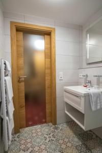 a bathroom with a wooden door and a sink at Doppelzimmer 14 in Heidenheim +2 photos