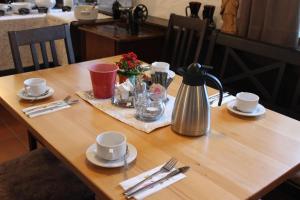 a wooden table with a tea kettle and cups on it at Einzelzimmer 15 in Heidenheim