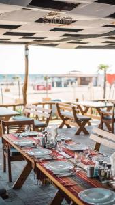 a wooden table with plates and wine glasses on it at Safari Beach & Camping in Donji Štoj