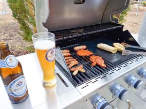 a grill with some food and a glass of beer at Apartment "Storch" in Wehlenberg