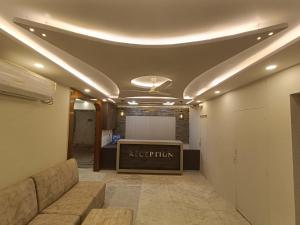 a meeting room with a couch and a stage at Hotel High Rise in Kolkata