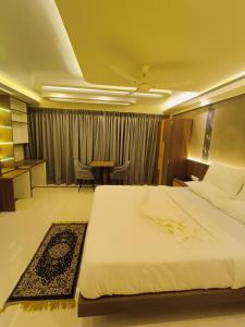 a bedroom with a bed and a table and chairs at Hotel High Rise in Kolkata +14 photos