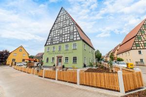 a green building with a pointed roof on a street at Apartment mit Terrasse "Blumentraum" in Spalt