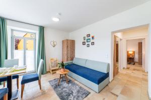 a living room with a blue couch and a table at Apartment mit Terrasse "Traumhopfen" in Spalt
