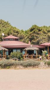 a building on the side of the water with people in it at Safari Beach & Camping in Donji Štoj