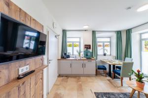a living room with a large television and a table at Apartment mit Terrasse "Traumhopfen" in Spalt