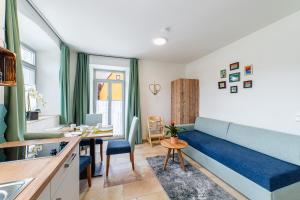 a living room with a blue couch and a table at Apartment mit Terrasse "Traumhopfen" in Spalt