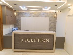 an office reception desk with a reputation sign on it at Hotel High Rise in Kolkata