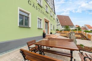a wooden table and benches in front of a building at Apartment "Hopfenblume" in Spalt