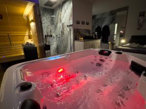 a bath tub filled with red water in a bathroom at Day SPA Design Muhr in Wehlenberg
