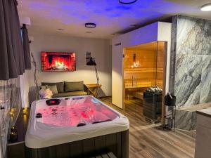 a large bath tub in a room with a fireplace at Day SPA Design Muhr in Wehlenberg