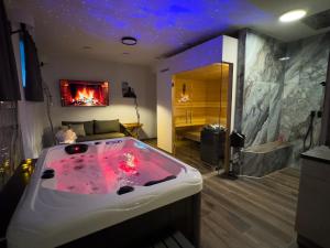 a large bath tub in a room with a fireplace at Day SPA Design Muhr in Wehlenberg