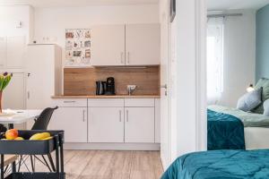 a kitchen with white cabinets and a table and a chair at Skandi Streudorf in Muhr amSee