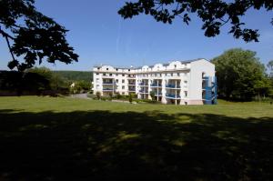 a large white building on a green field at Residence Hotel Les Ducs De Chevreuse avec Hébergement, Repas & PDJ, Séminaire, Bureau & Parking in Chevreuse