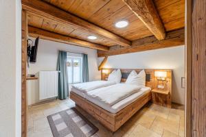 a large bed in a room with wooden ceilings at Wellness Apartment Suite "Paradies Suite" in Spalt +23 photos