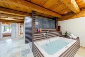 a large tub in a room with wooden ceilings at Wellness Apartment Suite "Paradies Suite" in Spalt