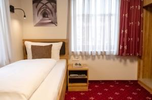 a small bedroom with a bed and a window at Einzelzimmer 16 in Heidenheim