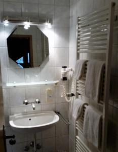 a bathroom with a sink and a mirror and towels at Hotel Heuberger Hof, Wehingen in Wehingen