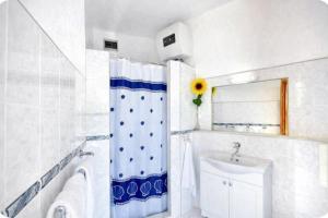 a bathroom with a shower curtain and a sink at Family home away on the beach, free parking at the house in Marusici  +49 photos