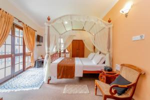 a bedroom with a canopy bed and a chair at Ard Lui Residence in Nuwara Eliya