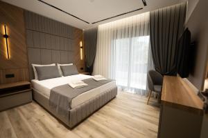 a bedroom with a bed and a large window at Sunset Luxury Apartments in Keramoti