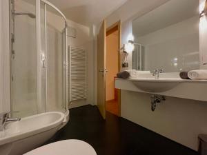 a bathroom with a sink and a tub and a toilet at Residence Remi in Senales