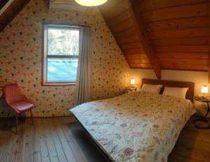 a bedroom with a large bed and a window at LOG-INN Hakuba in Hakuba +7 photos