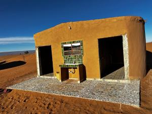 a small building in the middle of the desert at Atta Desert Camp in El Gouera
