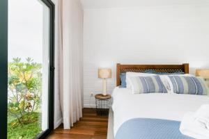 a bedroom with a bed and a large window at GuestReady - Good Vibes in Ponta Delgada