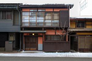 an apartment building with an open garage in front at IORI Stay in Takayama
