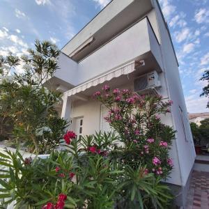 a building with pink flowers in front of it at Villa Una Maris - renovated 2026 in Pag