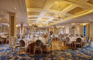 a banquet room with tables and chairs and a chandelier at Cork's Vienna Woods Hotel & Villas in Cork