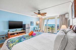 a bedroom with a large bed with a flat screen tv at Islander on the Beach 249 in Kapaa