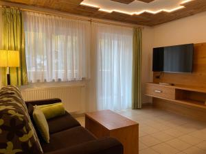 a living room with a couch and a flat screen tv at Residence Remi in Senales