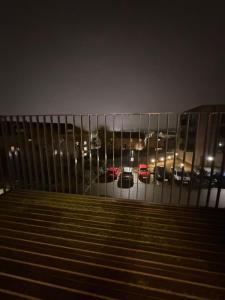 a fence in front of a parking lot at night at Prestige London Apartment Balcony Views in London