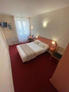 a bedroom with a bed and a red carpet at Nouvel Hotel in Lons-le-Saunier