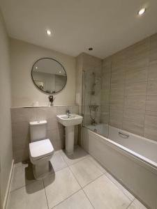 a bathroom with a toilet and a sink and a tub at Prestige London Apartment Balcony Views in London +8 photos