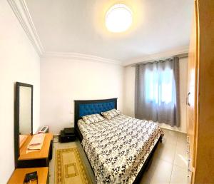 a bedroom with a bed and a desk and a window at Mina résidence A2 in Kelibia