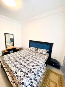 a bedroom with a bed with a black and white comforter at Mina résidence A2 in Kelibia