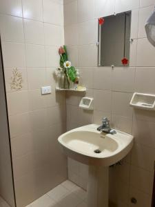 a white bathroom with a sink and a mirror at Morada de las Aves in Cali +46 photos