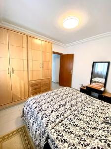 a bedroom with a bed and a dresser and a mirror at Mina résidence A2 in Kelibia