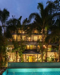 an exterior view of a building with a swimming pool at Anantya At Anamiva in North goa