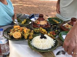 a table with plates of food and rice on it at Atta Desert Camp in El Gouera +65 photos