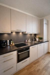 a kitchen with white cabinets and a sink at Stadthotel Carinthia in Klagenfurt