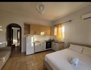 a bedroom with a white bed and a white refrigerator at Saranda Promenade Studio Apartment in Sarandë